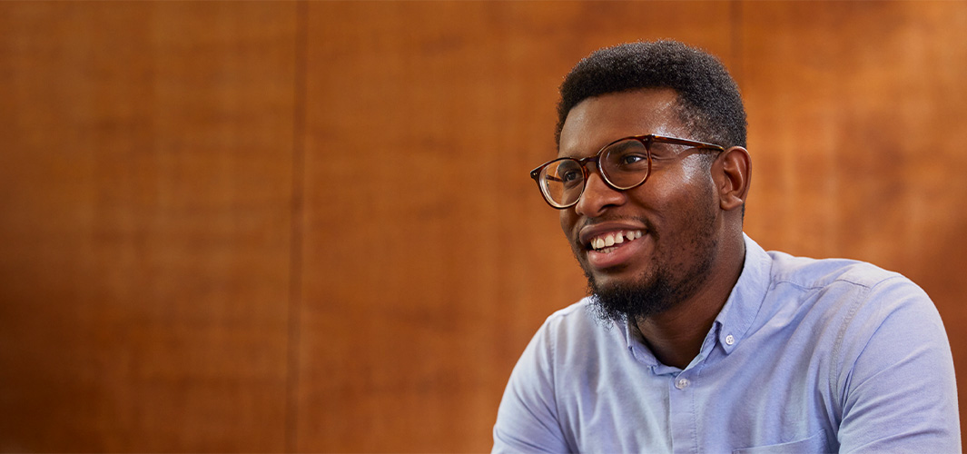 تشيدي يجلس مبتسماً وينظر جانباً.