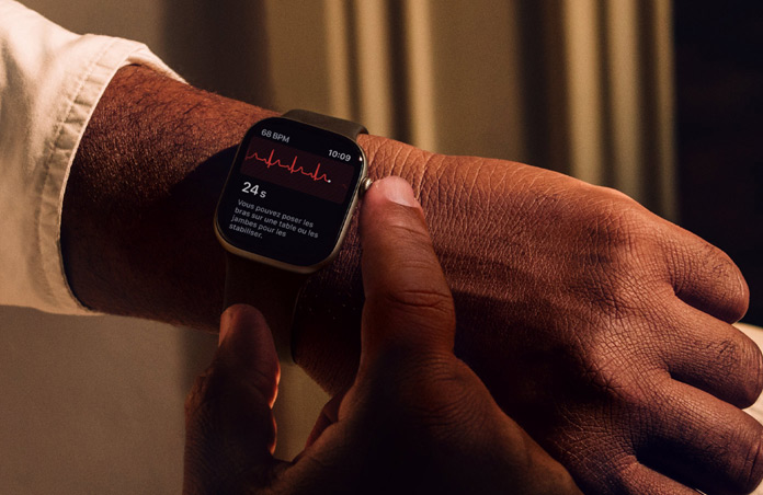 Une personne appuie sur la Digital Crown d’une Apple Watch Series 11 en maintenant la pression pour mesurer sa santé cardiaque dans l’app ECG