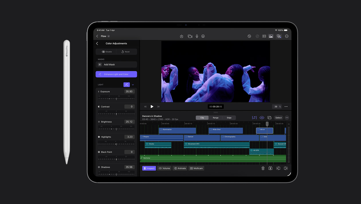 iPad Pro 13 screen showing colour adjustment panel on the left, woman dancing in moody lighting on the right, video clip timeline at the bottom, Apple Pencil to the left of the device