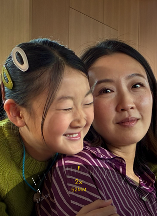 Tiek izmantota 2x telefoto funkcija, kadrā pietuvinot divus cilvēkus, kuri apkampjas