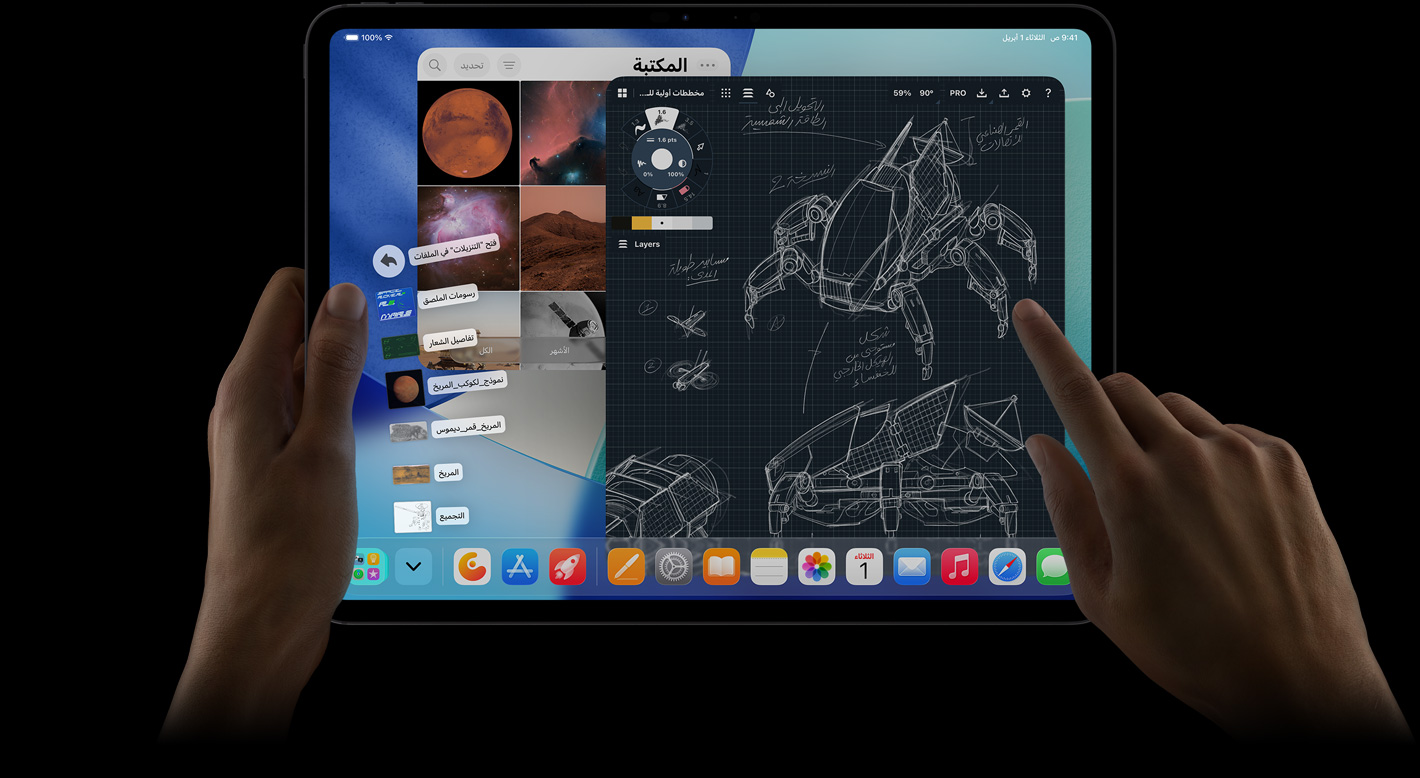 جهاز iPad Pro، الجزء الأمامي الخارجي، الوضع الأفقي، يد يمنى تشير إلى ملفات مجلد التنزيلات على شكل مروحة، الشاشة تعرض واجهة iPadOS 26 مع تطبيقات متعددة مفتوحة تشمل تطبيقاً لتعديل الصور مع مخططات مفصلة لروبوت وتعليقات توضيحية مكتوبة بخط اليد ومراحل تصميم متعددة، ومكتبة الصور