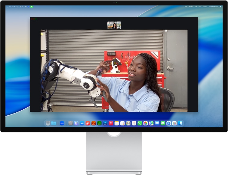 شخصان في مكالمة فيديو على شاشة Studio Display، نمط في الوسط يبقيهما في قلب الإطار أثناء تحرّك أحدهما لتصليح جهاز