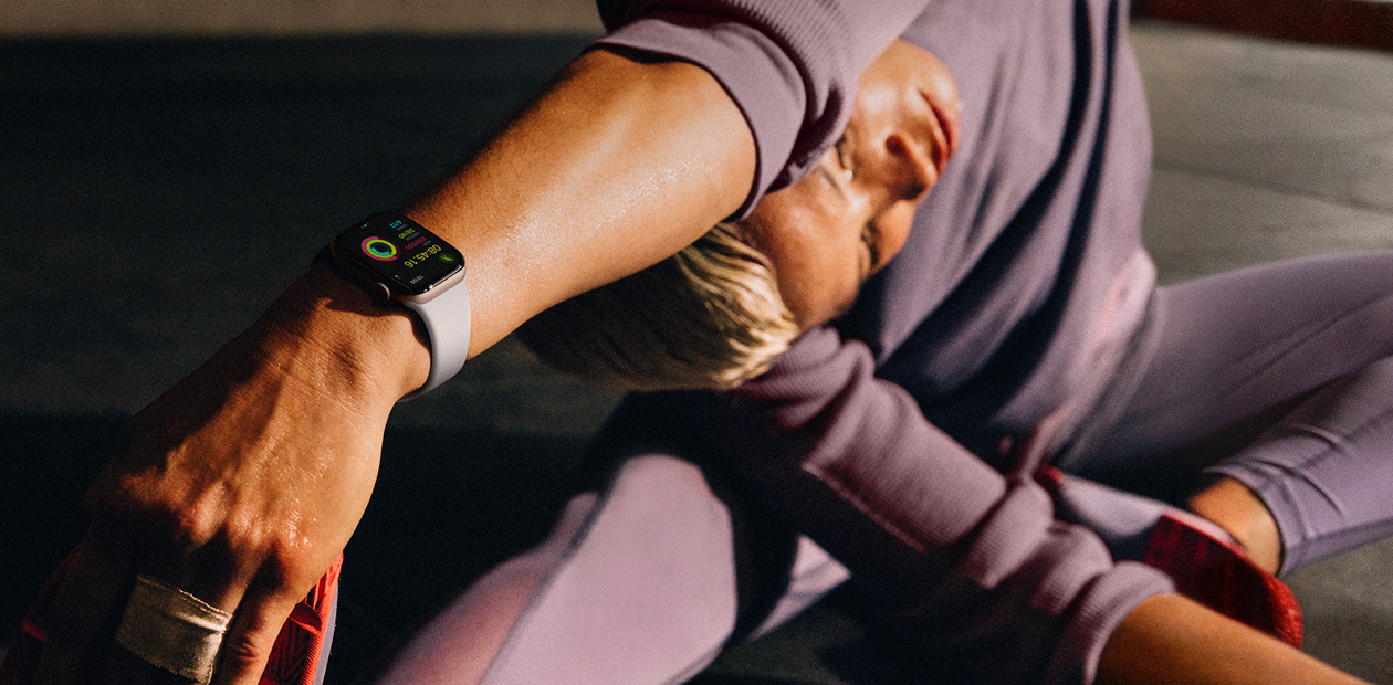 A woman wearing Apple Watch while stretching.