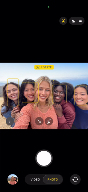 iPhone 17 Pro screen showing Centre Stage for photos feature and how to take a selfie of a group of people, with their faces highlighted