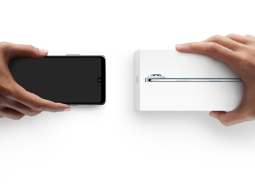 Twee handen wisselen telefoons uit, de linkerhand heeft een Android-telefoon zonder doos vast, de rechterhand heeft een nieuwe iPhone 17 Pro in de verpakking vast