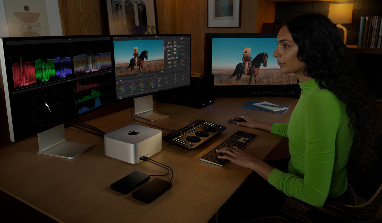A professional connected to Mac Studio, mixing music in DaVinci Resolve Studio using three displays