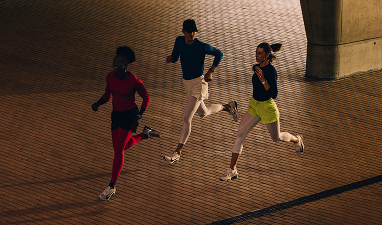 Three people running together, all wearing Apple Watch